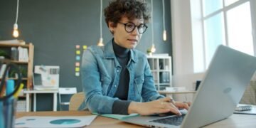 Professional working at a laptop in a modern office